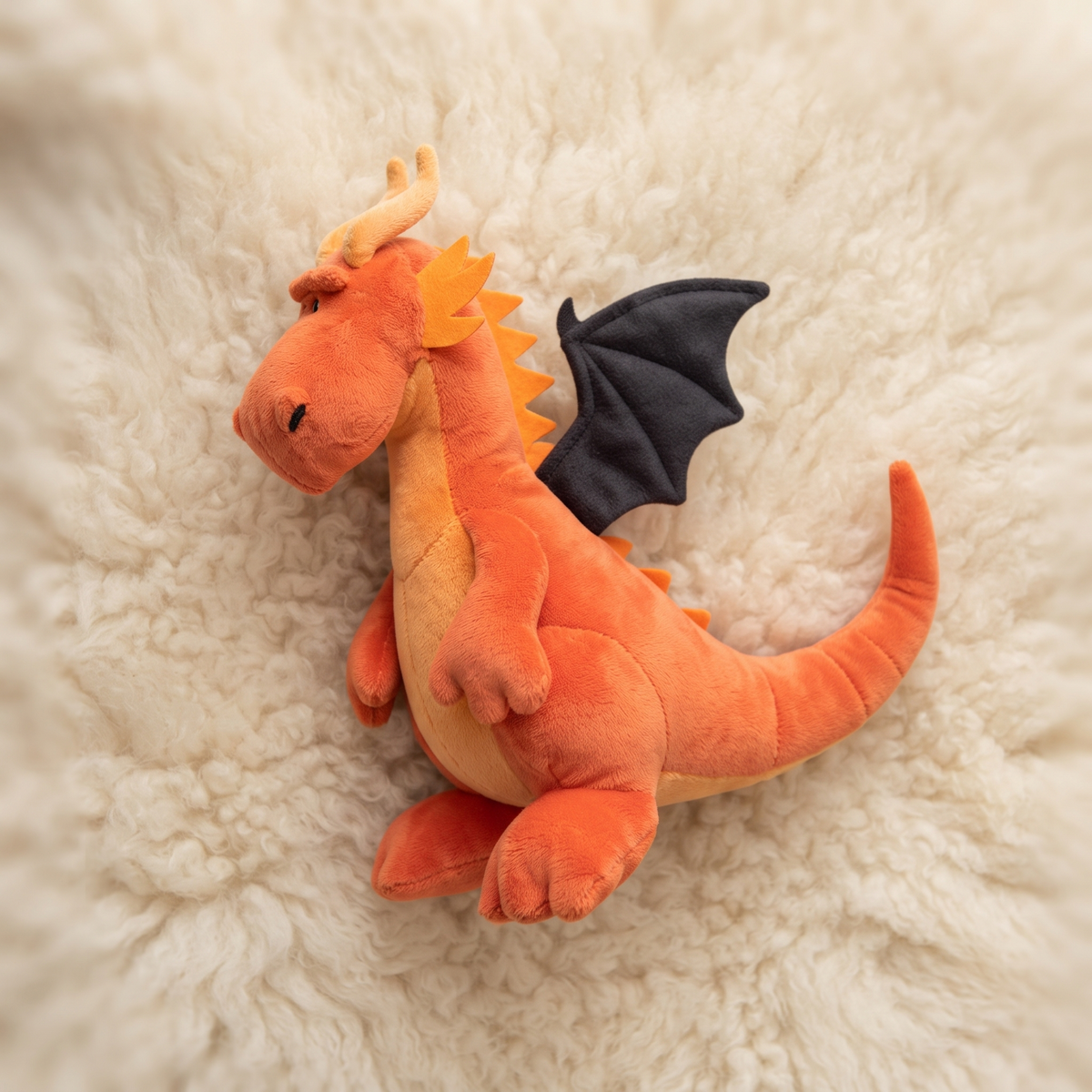 Oranger Drache mit schwarzen Flügeln